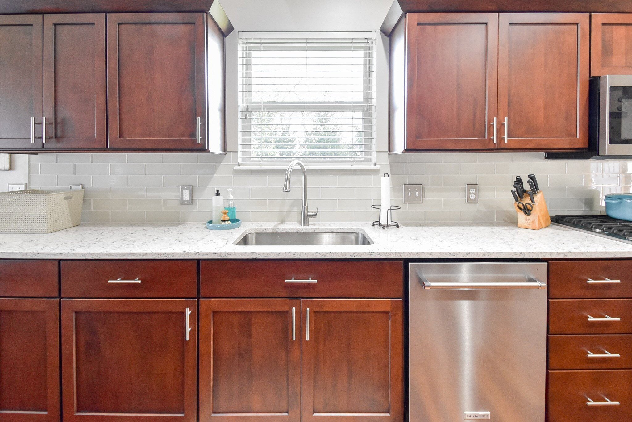 Kitchen with refaced cabinet doors, new hardware and a stone countertop