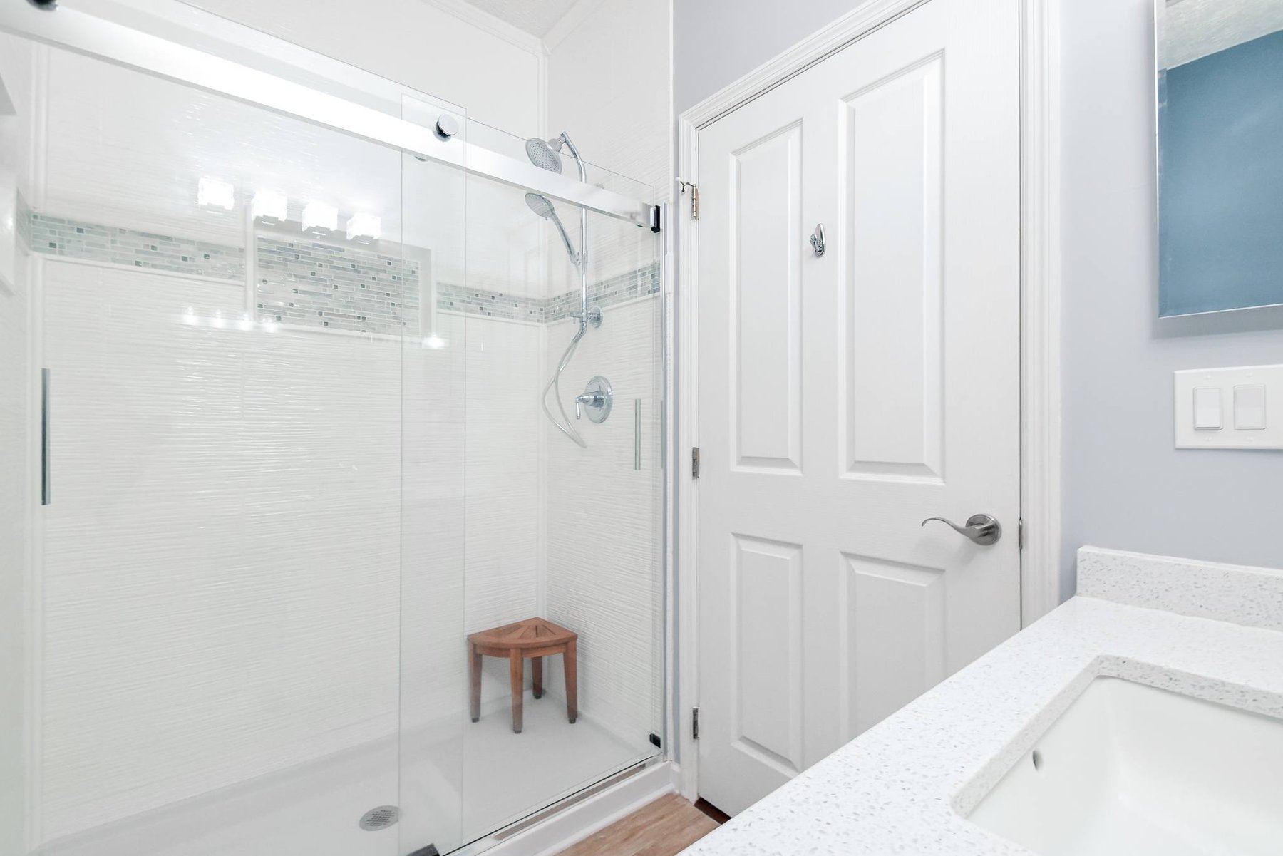 Remodeled bathroom with a double vanity, framed mirrors and glass block window