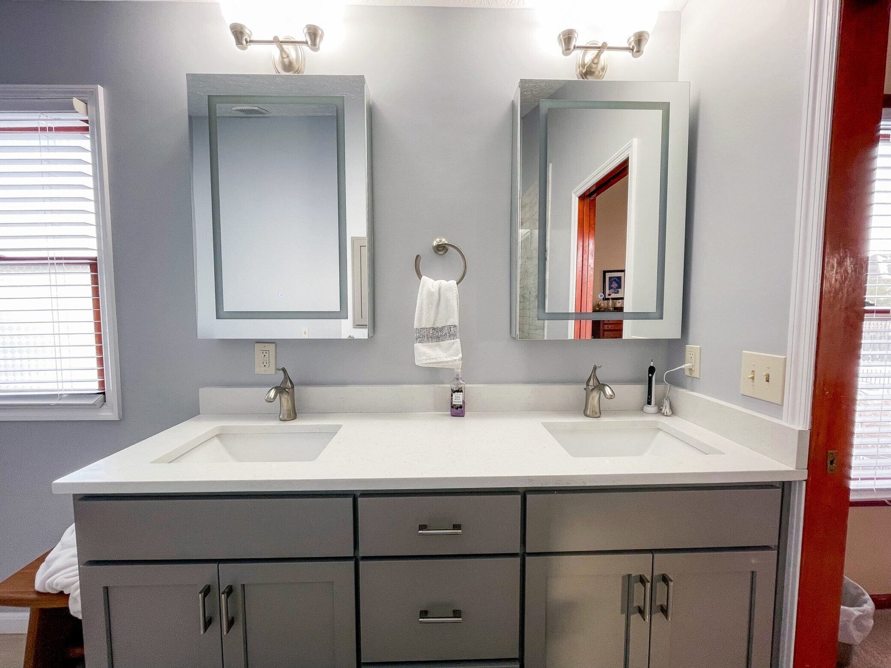 Bright remodeled bathroom with a walk-in shower and white tiled surround